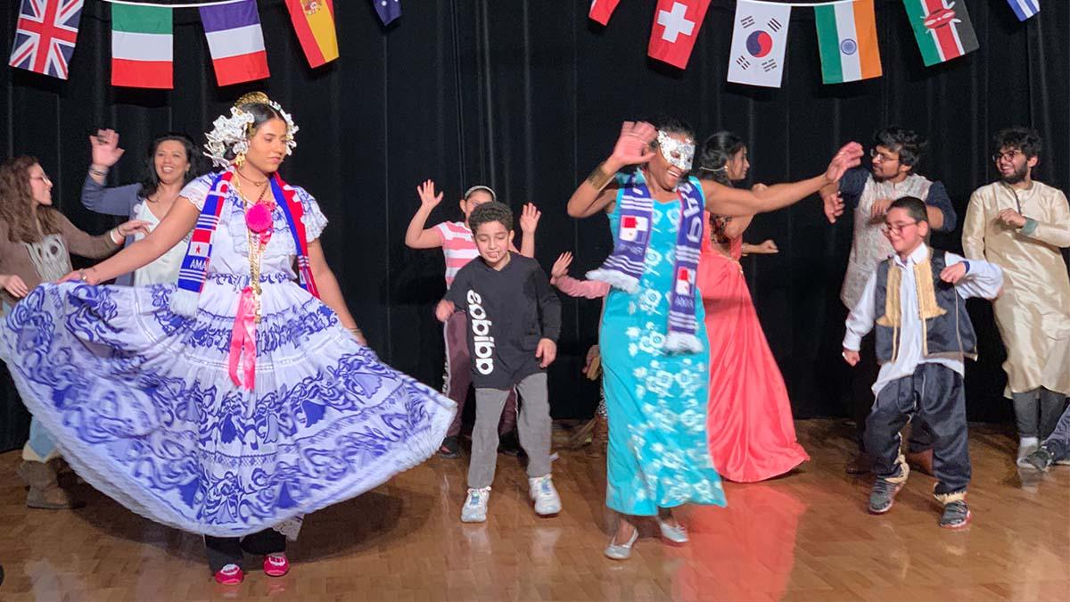 Performers teaching kids how to do a traditional Mexican 跳舞.