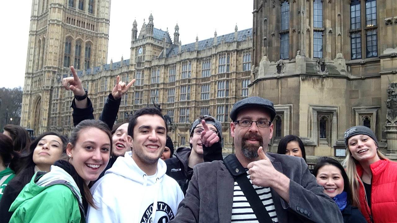 Brian Wolf and a group of students posing in front of Parliament.